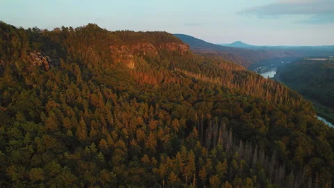 Sun sets over a vast forested expanse with a distant river winding through the Video stock 284332680