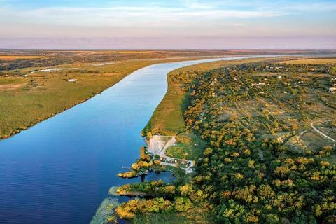 As the sun sets, the tranquil Southern Bug River winds through lush greenery, Stock Photos