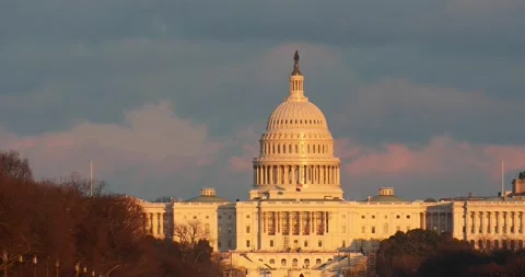 The sun sets at the US Capitol building in Washington, DC on a windy afternoon Video stock 148111286