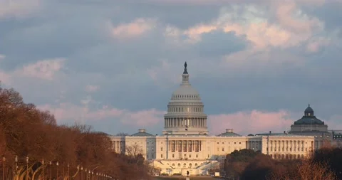 The sun sets at the US Capitol building in Washington, DC on a windy afternoon Stock Footage 148111300