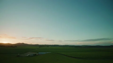 Sun setting across cane field farmlands and mountain ranges Stock Footage 153130425