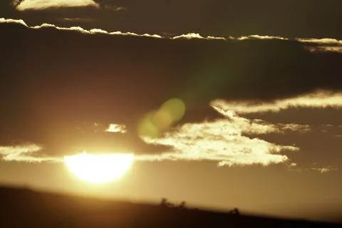 The sun is setting and the sky is cloudy Stock Photos