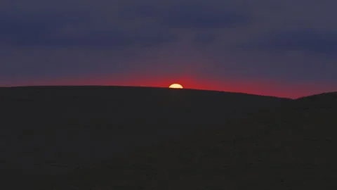 Sun setting in barren desert Stock Footage 275644113