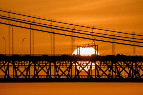Sun setting behind 25 de Abril bridge, Lisbon, Portugal, in silhouette Stock Photos