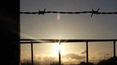 Sun setting behind barbed wire Video stock 38711155