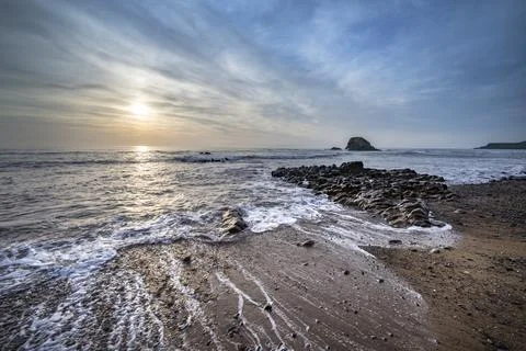 Sun setting behind Black Rock on Widemouth Bay Cornwall Stock-Fotos