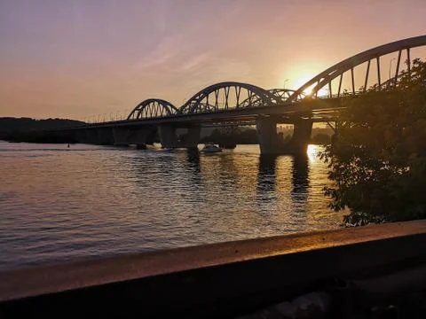 Sun setting behind the bridge on the Dnipro river in Kyiv, Ukraine. Foto stock