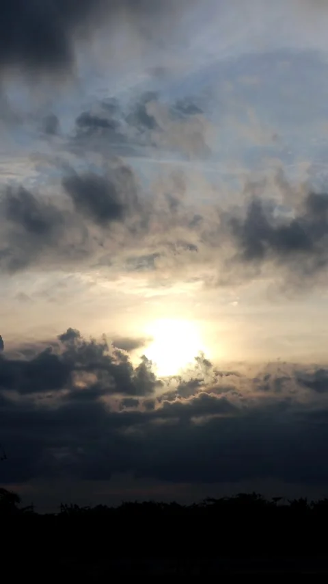 The sun is setting behind the clouds. Stock Footage 296824032