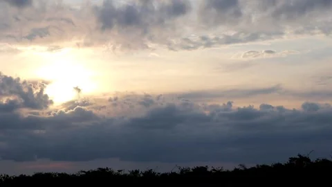 The sun is setting behind the clouds. Stock Footage 296824214