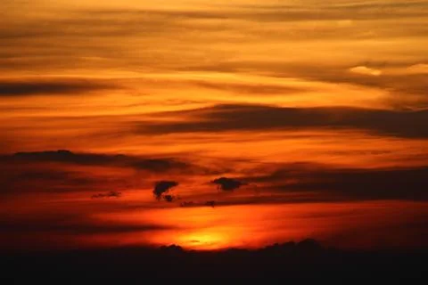 The sun setting behind the clouds. Orange sky. Amazing sunset Foto stock