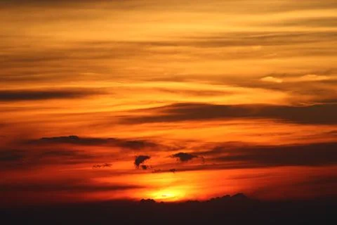 The sun setting behind the clouds. Orange sky. Amazing sunset Stock Photos