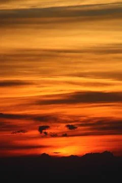 The sun setting behind the clouds. Orange sky. Amazing sunset Stock Photos