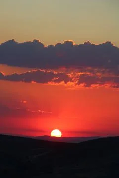 The sun setting behind the clouds. Orange sky. Amazing sunset Stock Photos
