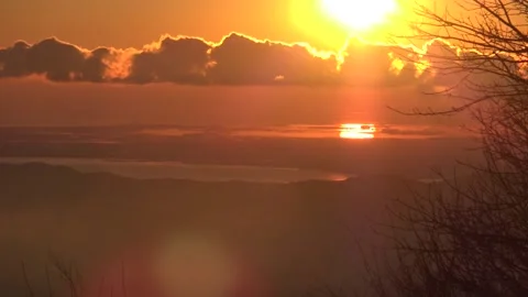 Sun setting behind clouds over the sea Stock Footage 158757950