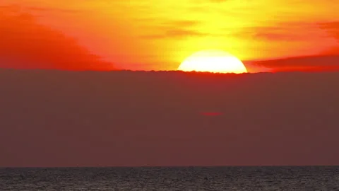 Sun setting behind clouds over ocean horizon Stock Footage 337628745