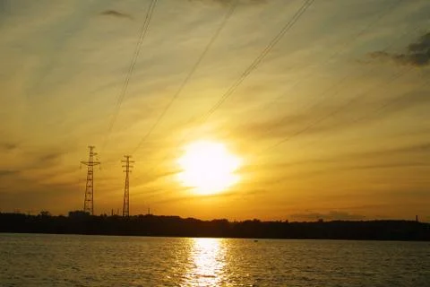 Sun setting behind electricity pylon Stock Photos