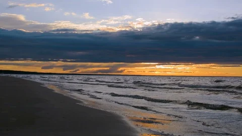 Sun setting behind epic rainy clouds in colorful vibrant ocean twilight 스톡 동영상 91393665