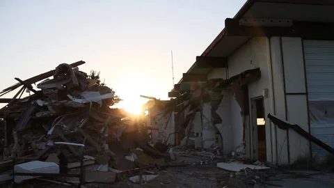 Sun setting behind garage and trash dump Stock Footage 95113843