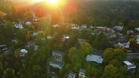 Sun setting behind hills and cars driving on curve road Stock-Footage 164410132