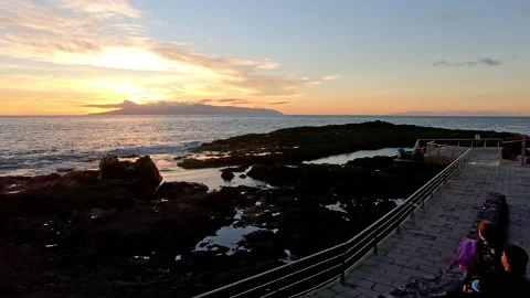 Sun setting behind the island of La Gomera, boys watching it, colorful 4k Stock Footage 170675313