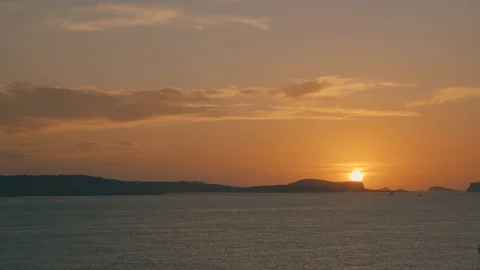 Sun setting behind island mountains Stock Footage 122794033