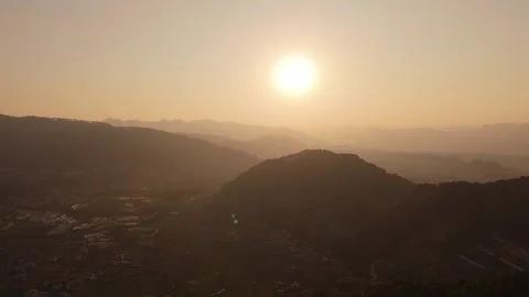 Sun setting behind layered Himalayan ridgelines above Kathmandu valley Stock Footage 345606385