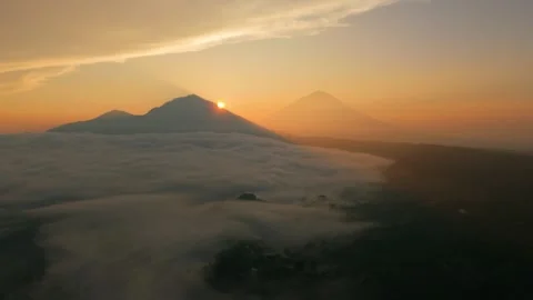 The sun is setting behind a mountain covered in clouds Stock Footage 265447864