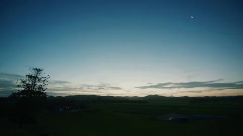 Sun setting behind mountain range with blue colorful sky Stock Footage 153230260