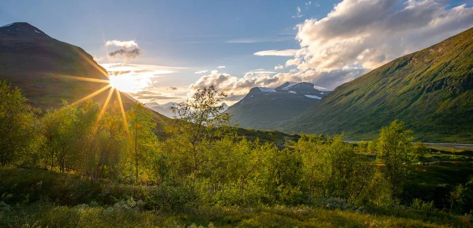 Sun setting behind the mountain in remote Arctic valley. Sarek National Park Stock Photos