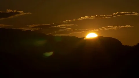 Sun setting behind mountains during dusk Stock Footage 76002918