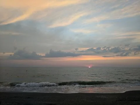 Sun Setting behind the ocean Stock Photos