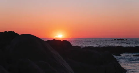 Sun setting behind rocks over ocean time lapse 스톡 동영상 146175288
