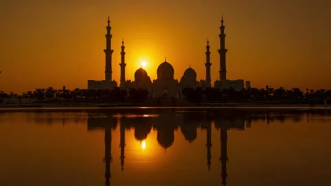 Sun setting behind the Sheikh Zayed Grand Mosque in Abu Dhabi Stock Footage 179376011
