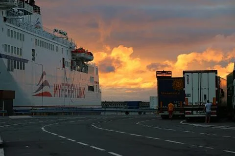 Sun setting behind ship docked at Calais Stock Photos