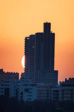 Sun Setting Behind a Tall Building with Orange Hues Stock Photos