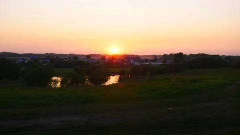The sun setting behind the Tula River and silhouetted trees on the beautiful and Stock Photos