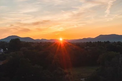 Sun Setting Behing the Mountain Horizon Casting an Orange Sunshine Stock Photos