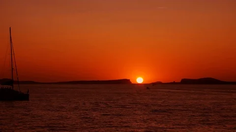 Sun setting between two mountain island at the sea on a calm and peaceful summer Stock-Footage 123089427
