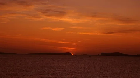 Sun setting between two mountain island at the sea on a calm and peaceful summer Stock Footage 123089937