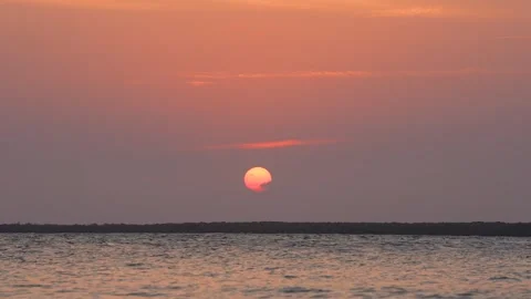 Sun Setting into Calm Red Horizon Stock Footage 305957328