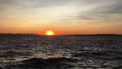 Sun setting into a dark stormy sea Stock Footage 80105298