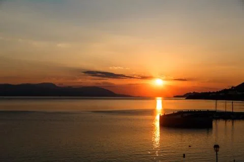 Sun setting down over the sea, The red disc of the sun touches the horizon Stock Photos