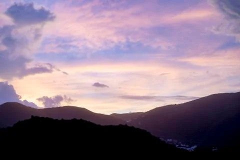 Sun setting during blue hour over hills and mountains Stock Photos