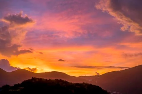 Sun setting during blue hour over hills and mountains Stock Photos