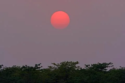 Sun Setting into the Evening Haze Stockfoto's