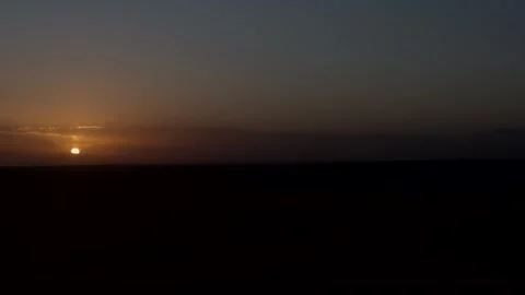 Sun setting on horizon over dark Moroccan desert landscape Stock Footage 337495750