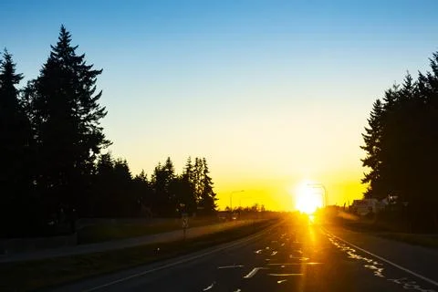 Sun setting on the horizon over Highway 101 in Sequim, Washington Stock Photos