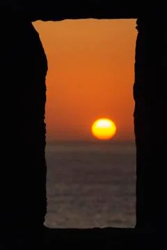 Sun is setting on the horizon through a window Stock Photos