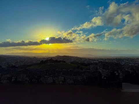 Sun setting into the horizon. The view is from high ground green mountain Stock-Fotos