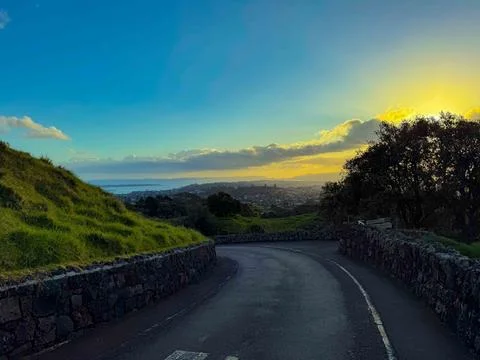 Sun setting into the horizon. The view is from high ground green mountain Foto stock